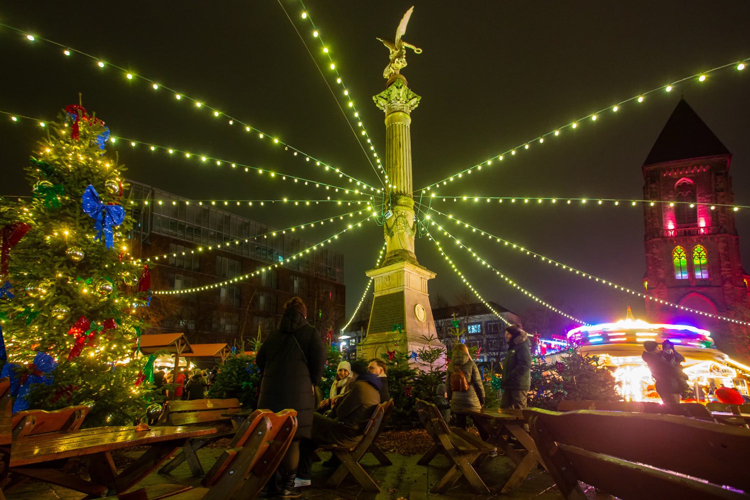 Weihnachtsmarkt auf dem Altmarkt Oberhausen: Lichterketten strahlen vom Denkmal über den Platz
